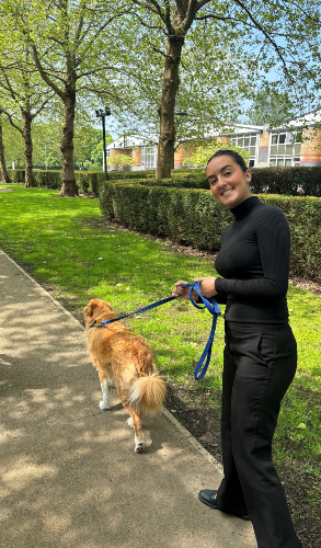 A picture of Matilda walking a dog during the Wellbeing  Dog Service