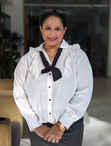 Picture of Bindu smiling in a black and white dress