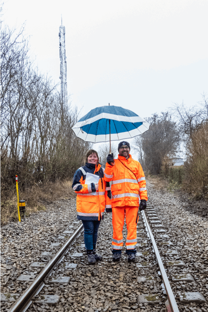 this is a image of two people standing on a railway track