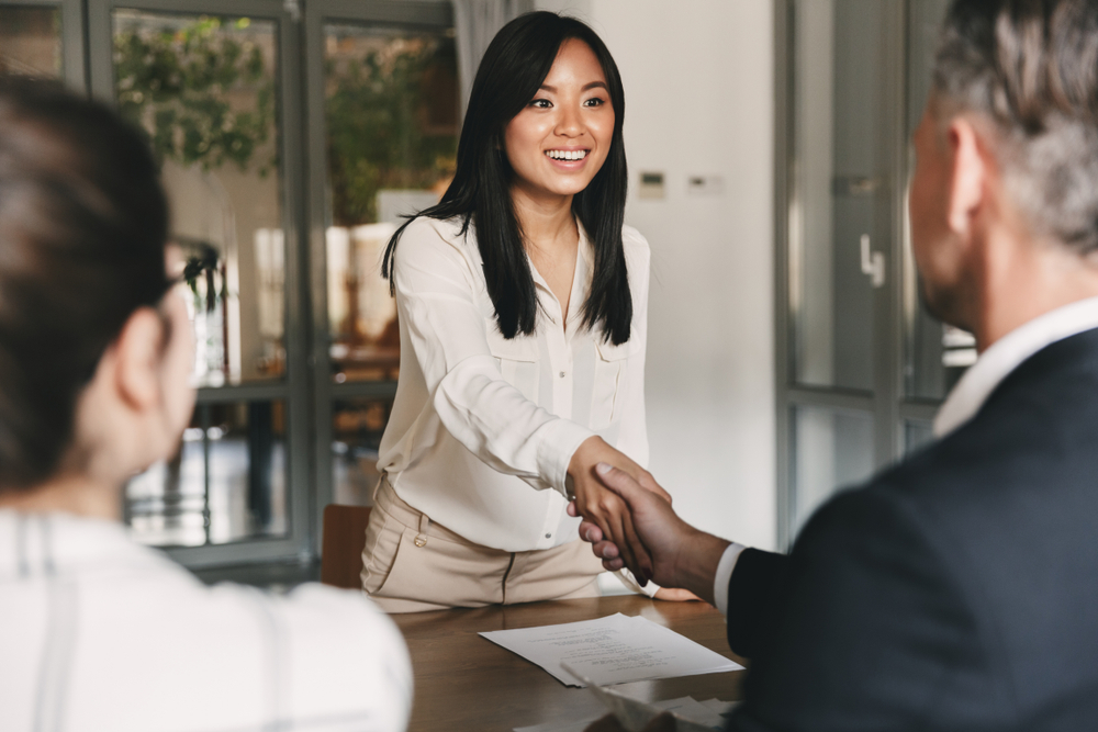 women in a white shirt shaking a man's hand