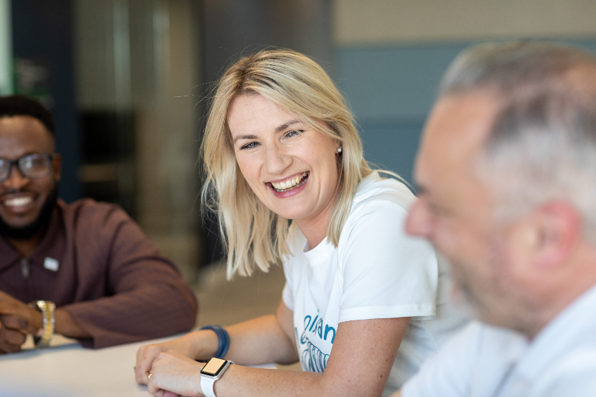 lady with blonde hair smiling just off camera