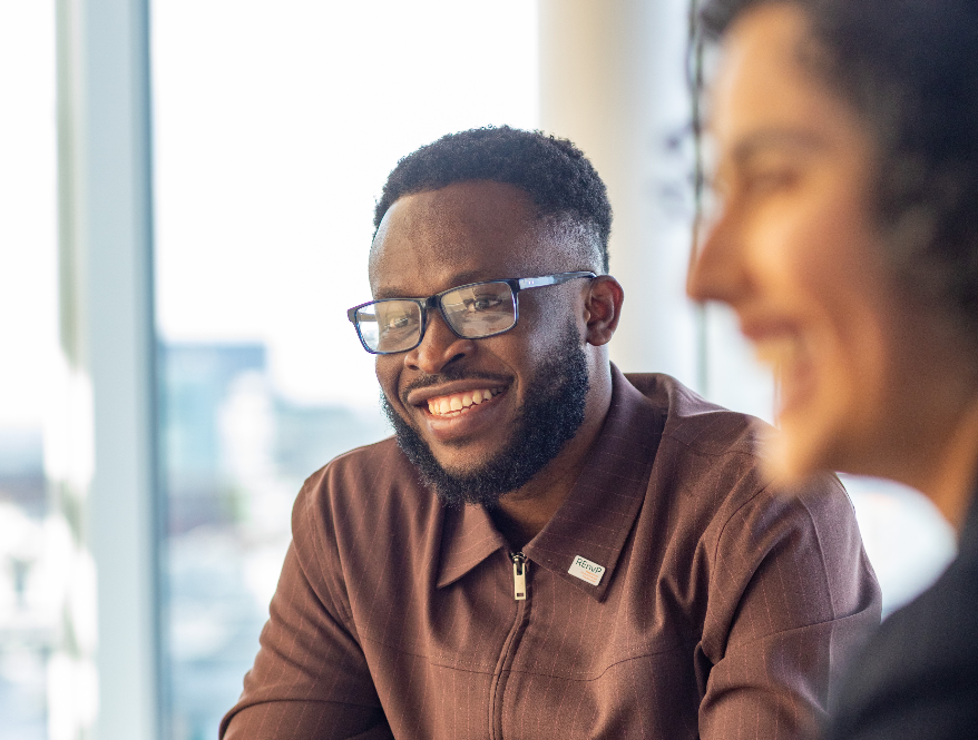 young man wearing glasses smiling just off camera