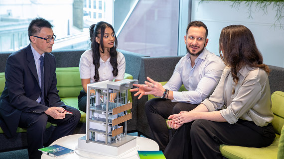 Group discussing a building model in a modern office.