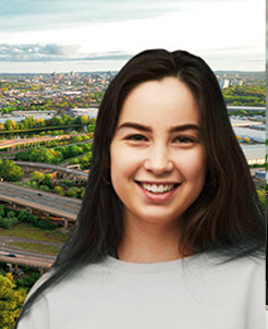 Smiling young woman in front of an urban highway infrastructure view.