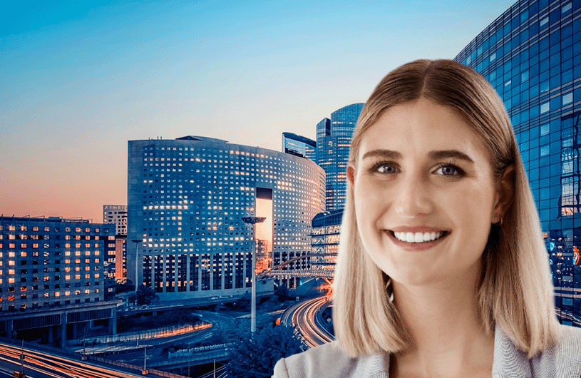 Smiling young woman in front of an urban highway infrastructure view.