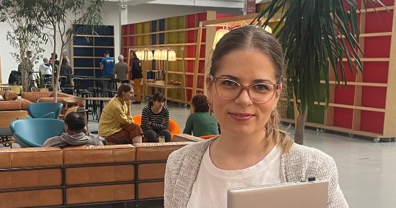 Woman holding laptop in modern office