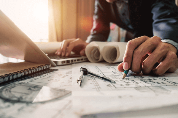 A man planning on a table with papers and laptop