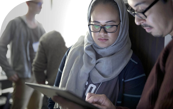 two women checking tablet