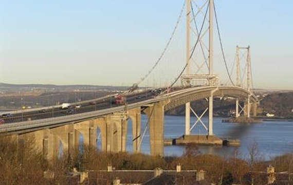 View of a large suspension bridge over a body of water with traffic on it.