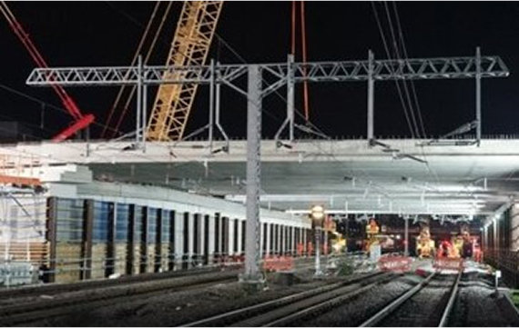 View of a large suspension bridge over a body of water with traffic on it.