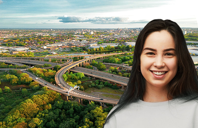 Smiling young woman with long dark hair standing in front of a cityscape with a sprawling highway interchange, symbolizing diversity and inclusion.