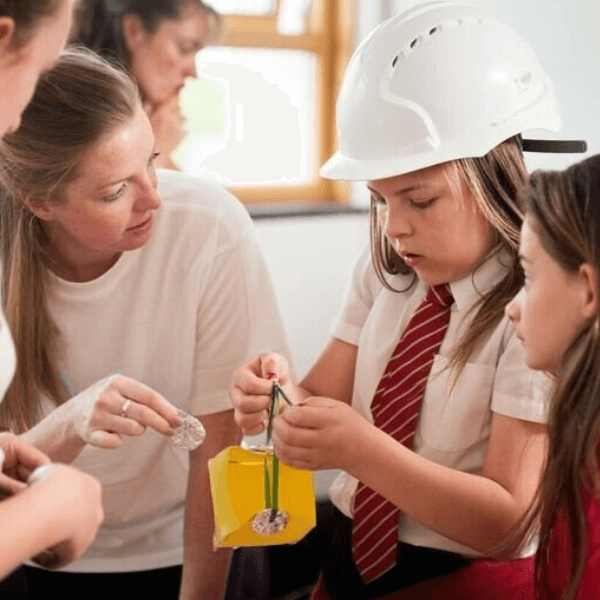 Child wearing hard hat learning engineering project
