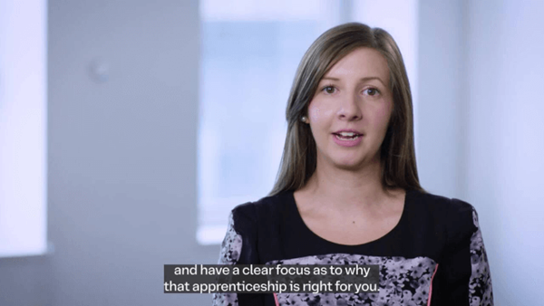 Woman speaking in a well-lit indoor setting, with subtitles about choosing the right apprenticeship.