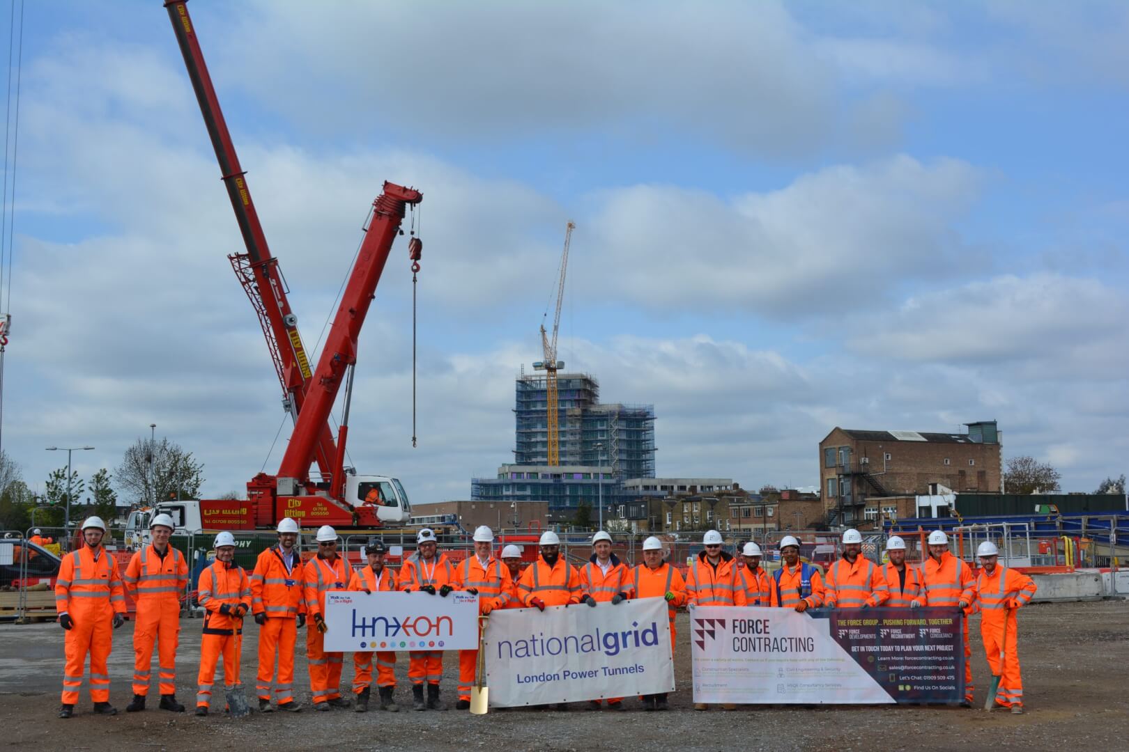 people holding a flag at atkins construction site.