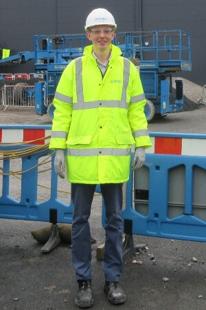 Person wearing high-visibility safety gear at a construction site.