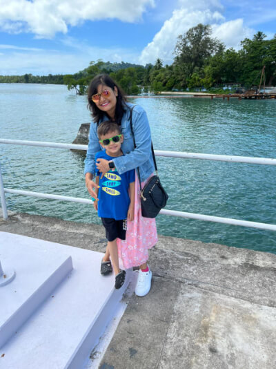 Photo of Arya smiling towards the camera with her son