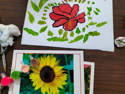Colorful hand-painted flower artwork on white paper.