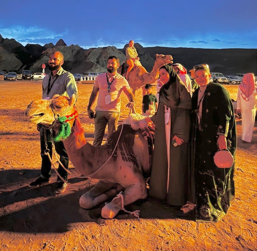 A group of people in desert with camels