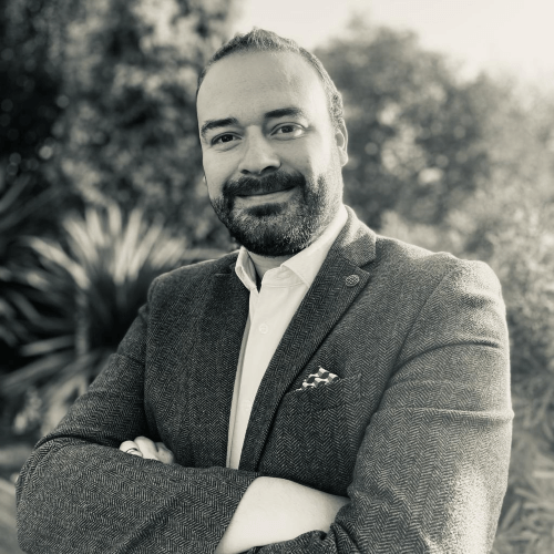 A profile picture of Ron smiling, in a black and white filter