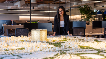 female AtkinsRéális colleague looking over a model of a project