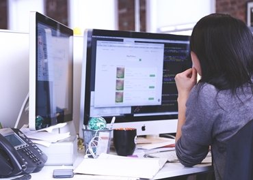 female engineer studying plans on computer screens