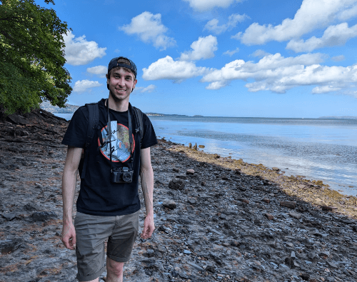 A picture of Euan standing near the beach