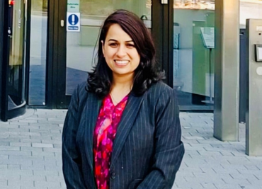 Alpa in a blazer smiling at the camera