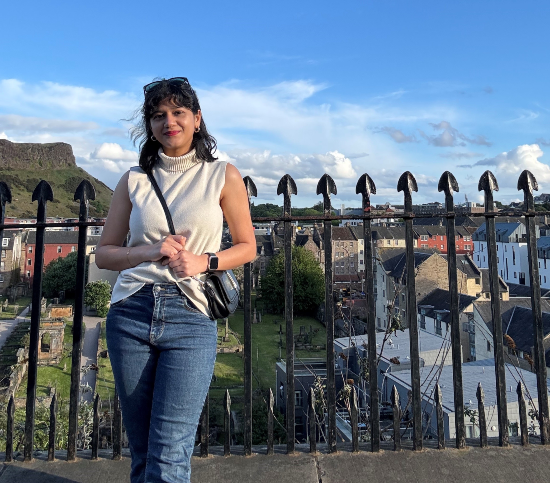Image of Devashree standing near a fence