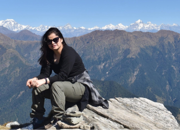 Image of piriya sitting on a mountain top