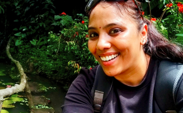 Selfie of Archana smiling in a garden