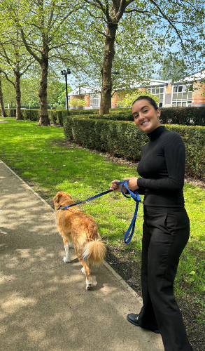 A picture of Matilda walking a dog during the Wellbeing Dog Service